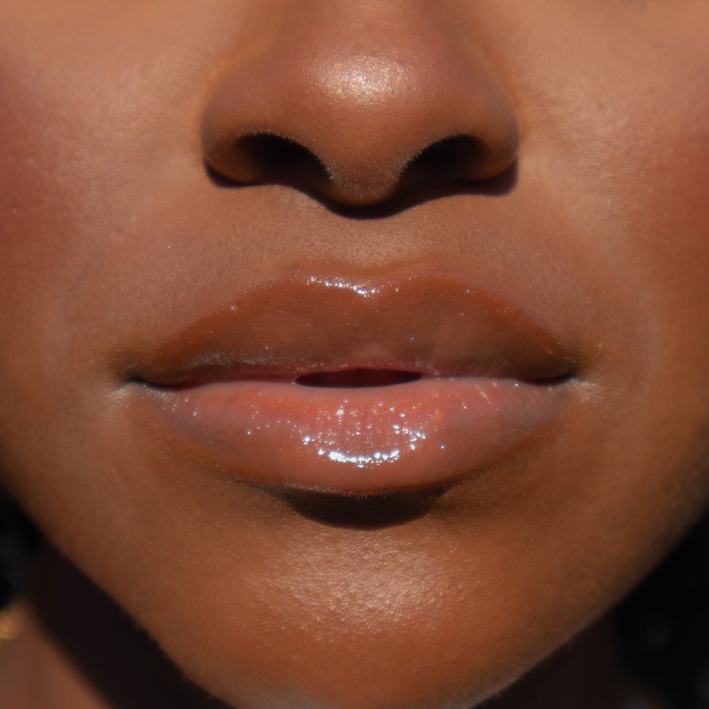 Zaé vegan lip gloss hydrating formula"
"Zaé cruelty-free lip gloss tube applicator"
"Zaé lip gloss swatches on hand"
"Zaé lip gloss packaging sustainable beauty"