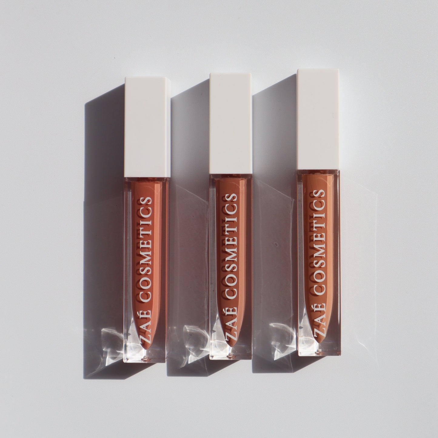 "Zaé vegan lip gloss hydrating formula"
"Zaé cruelty-free lip gloss tube applicator"
"Zaé lip gloss swatches on hand"
"Zaé lip gloss packaging sustainable beauty"